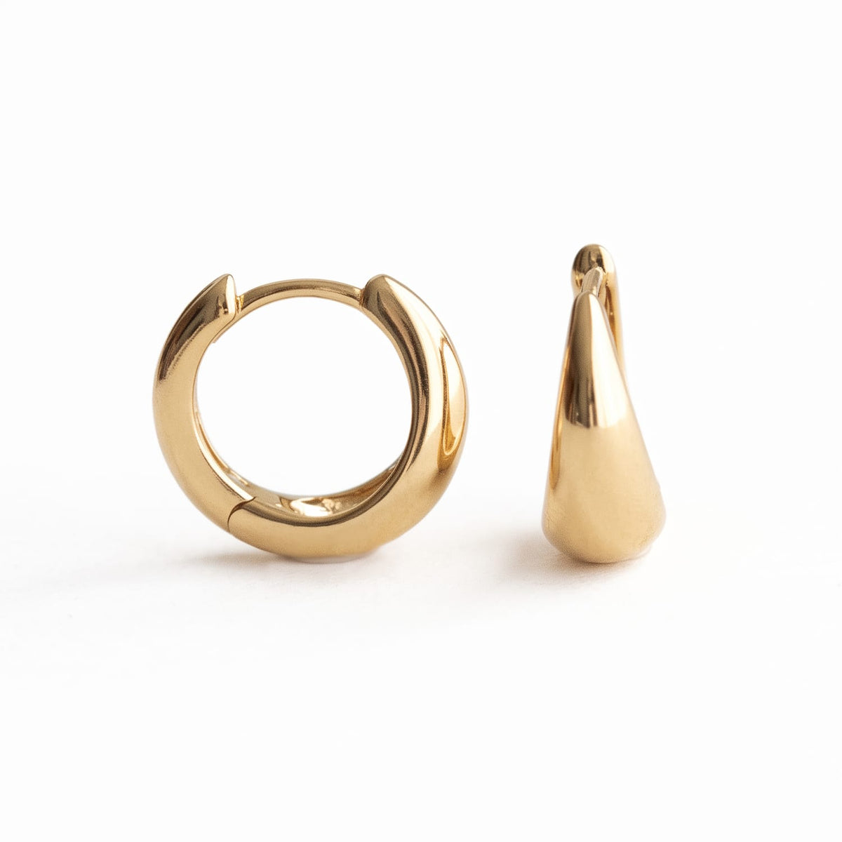 A pair of polished gold huggie hoop earrings, one shown from the front and the other from a side profile, on a clean white background.